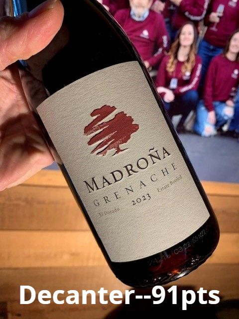 A hand holding a bottle of Madroña Grenache. Text on the photo reads Decanter, 91 points